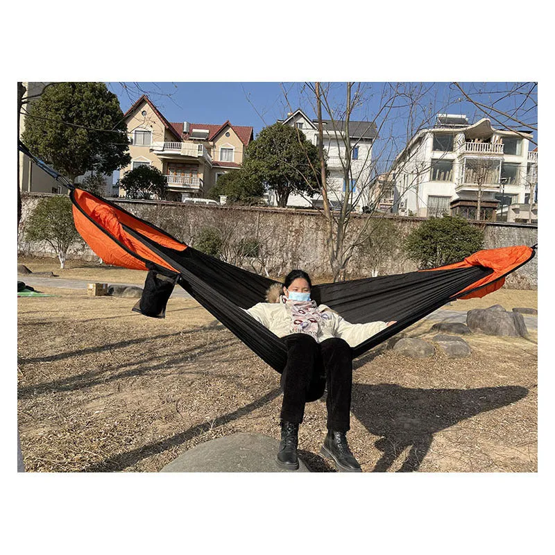 Automatic quick-opening double hammock with mosquito net and sun shades in Army Green Orange set up between trees outdoors