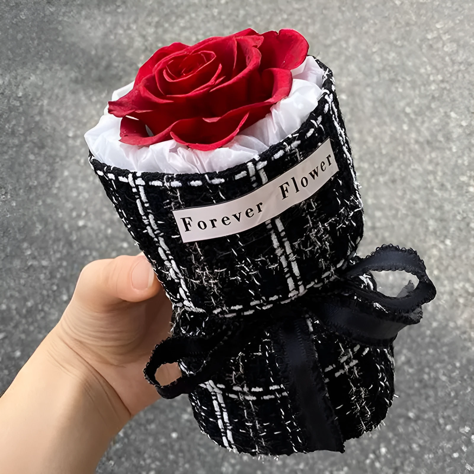 Dried flower eternal life bouquet in classic flowerpot style, red colour variant, on a tabletop