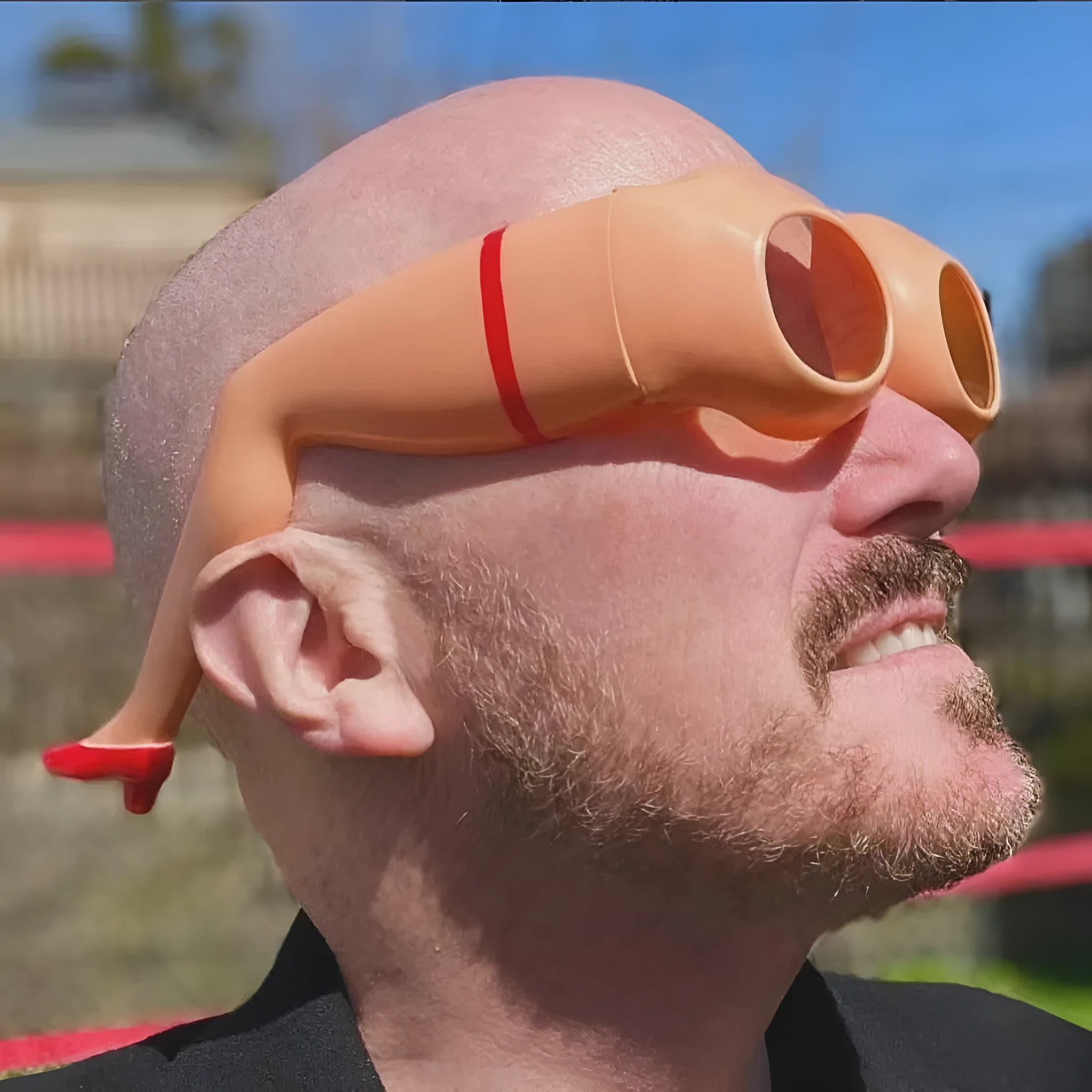 Orange plastic novelty sunglasses designed in the shape of a hip and leg.