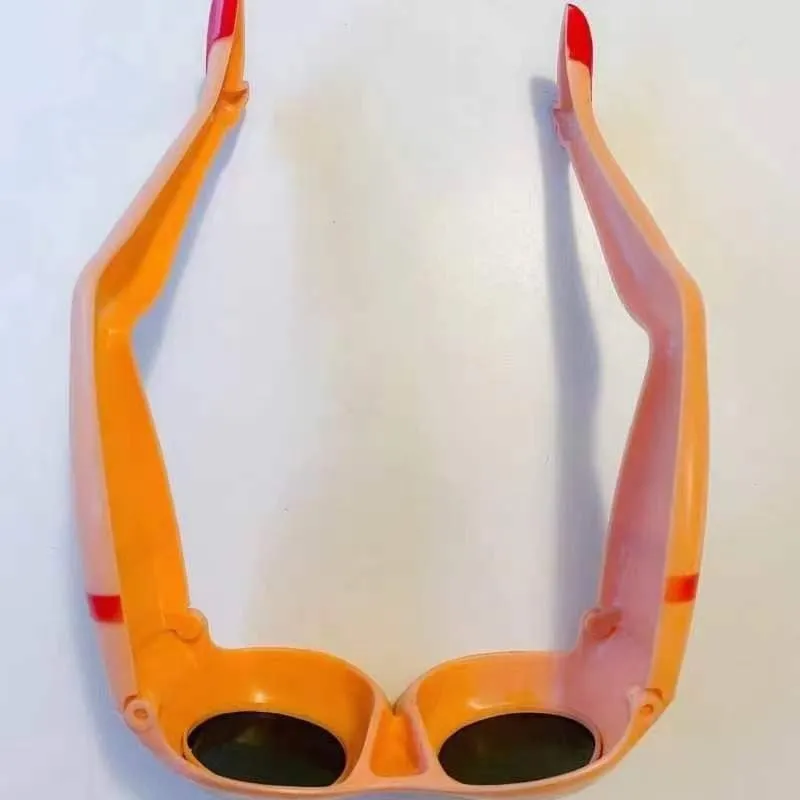 Orange plastic novelty sunglasses designed in the shape of a hip and leg.