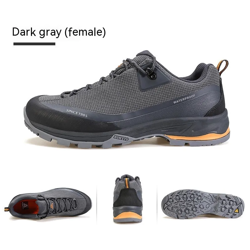 Men's low-top hiking boots in black with leather mesh upper and rubber outsole on a rocky path.