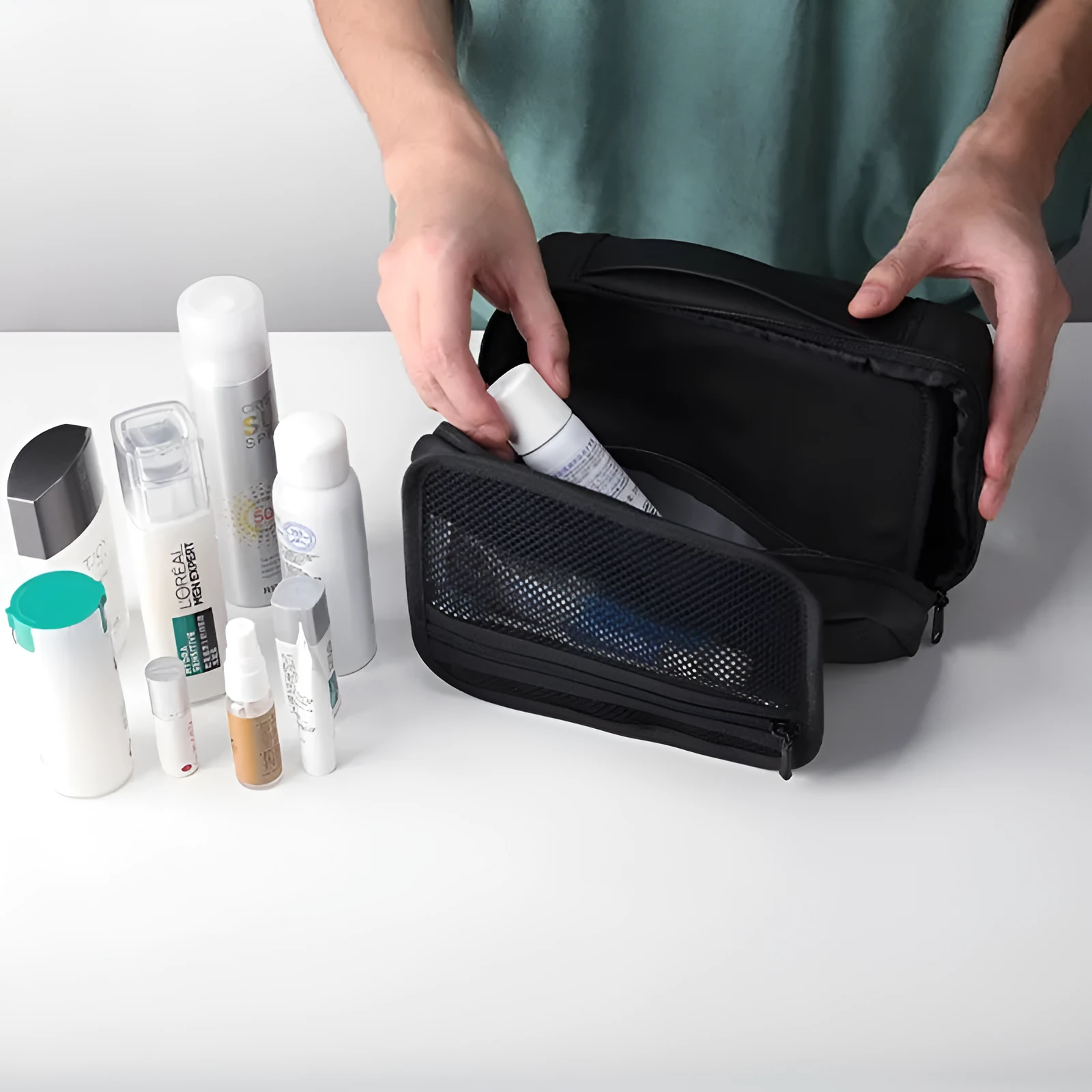 Black Oxford cloth toiletries bag with multiple compartments open, showing wet-dry separation design.