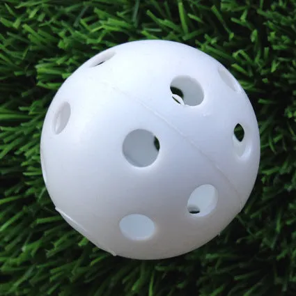 Hollow plastic golf practice ball in orange colour on indoor surface