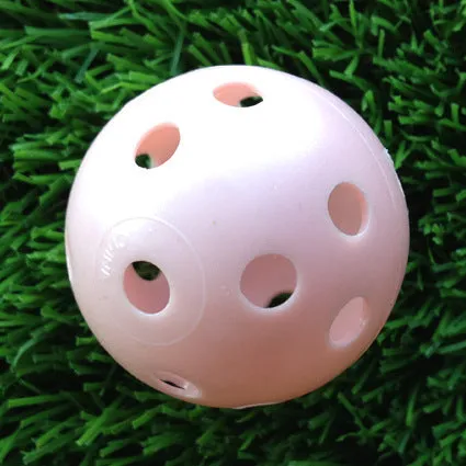 Hollow plastic golf practice ball in orange colour on indoor surface