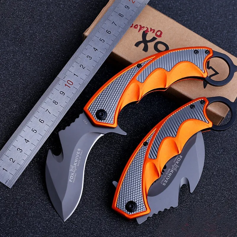 Orange folding knife with steel handle and 8.2cm blade open on outdoor surface showing total length and grip texture