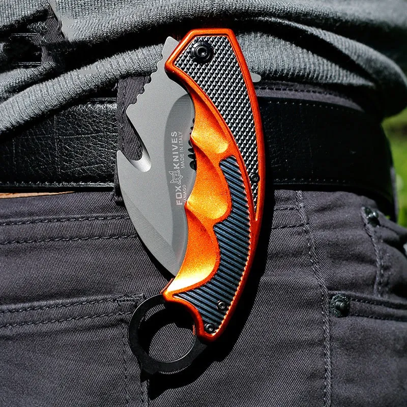 Orange folding knife with steel handle and 8.2cm blade open on outdoor surface showing total length and grip texture