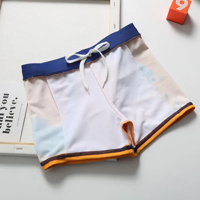 Cartoon dinosaur swimming trunks set for boys in light blue, dark blue, and orange colours