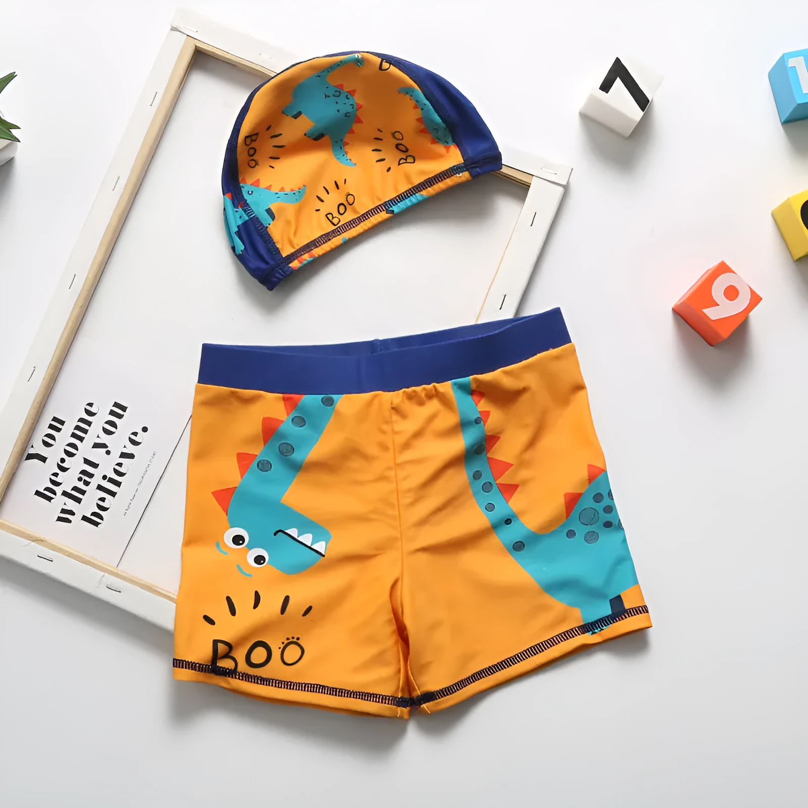 Cartoon dinosaur swimming trunks set for boys in light blue, dark blue, and orange colours