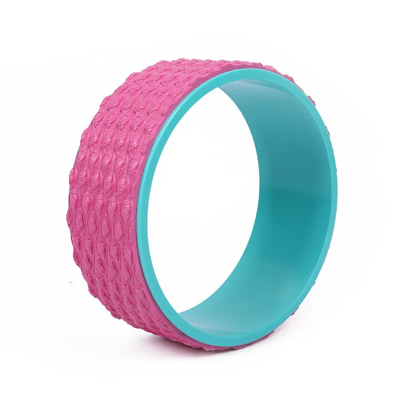 Massage point yoga wheel in black on floor with raised texture surface for backbending and Pilates muscle relaxation