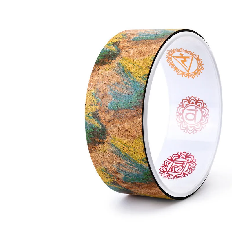 Cork yoga wheel in classic black, 32cm diameter, on a yoga mat in a home studio