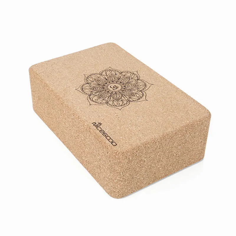 High-density natural cork yoga brick with rounded edges on a wooden floor
