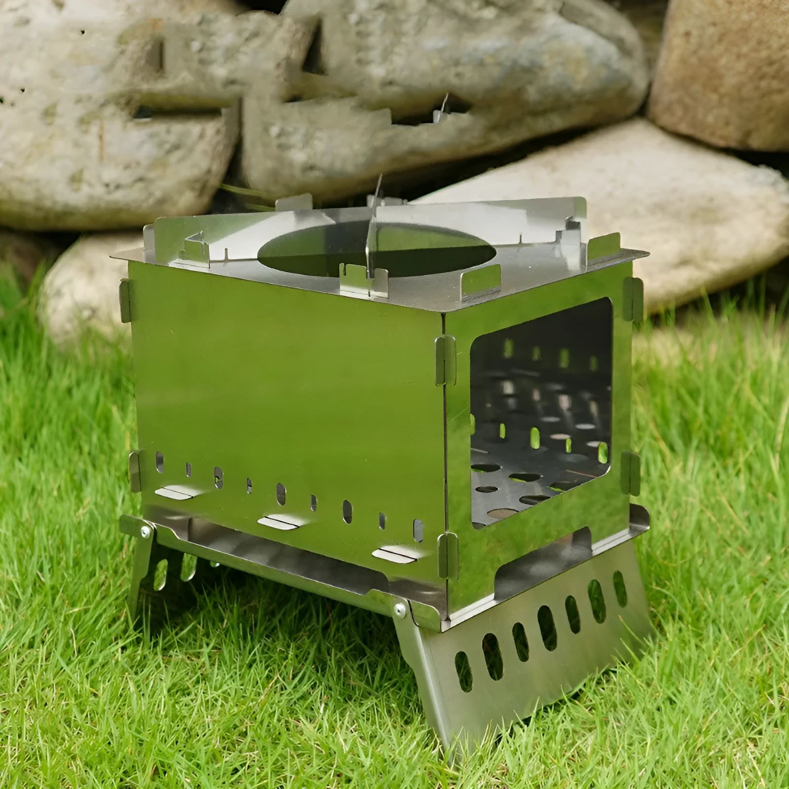 Silver outdoor folding card stove with grill mesh and storage bag on table