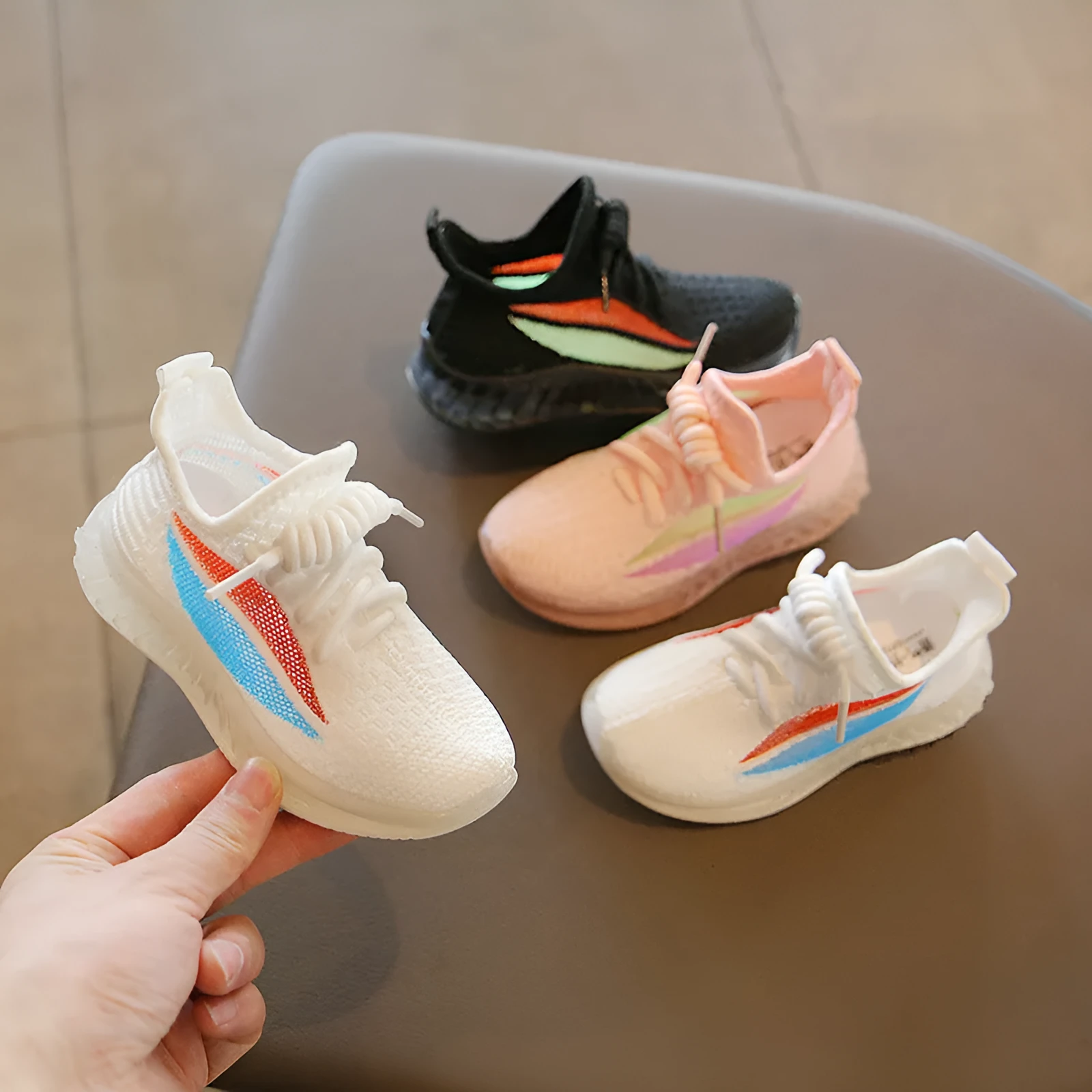 Children's white woven mesh sports shoes with rubber sole, side view on light background