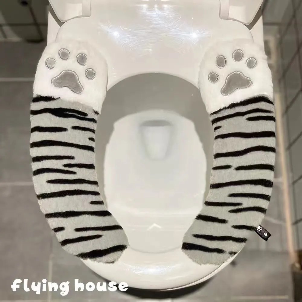 Plush toilet seat cushion with adhesive Velcro fastener in black and white stripes for bathroom use