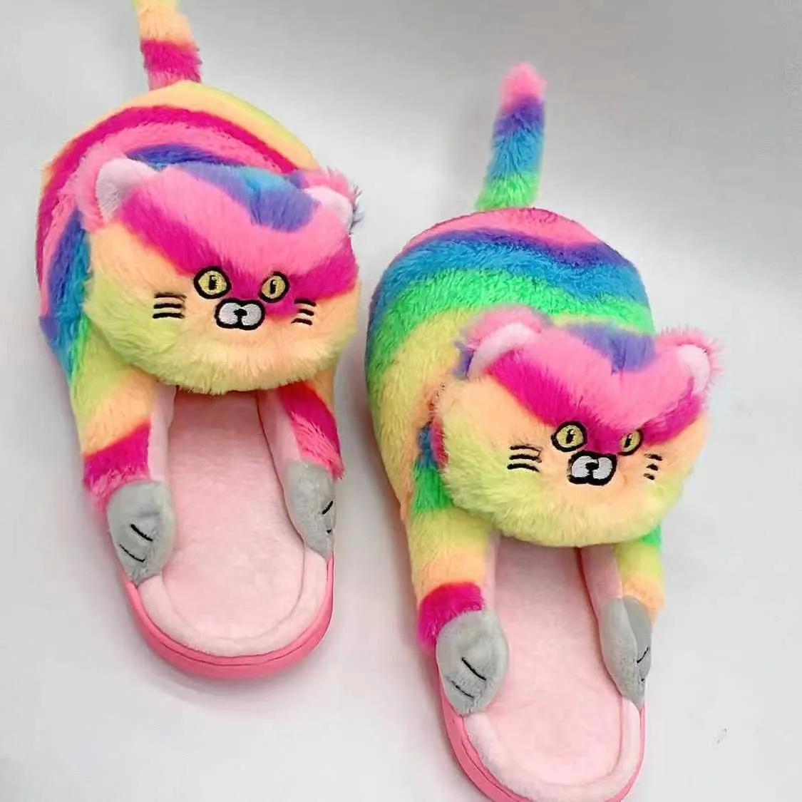 Pair of beige cat hug plush cotton slippers with non-slip sole on a soft floor