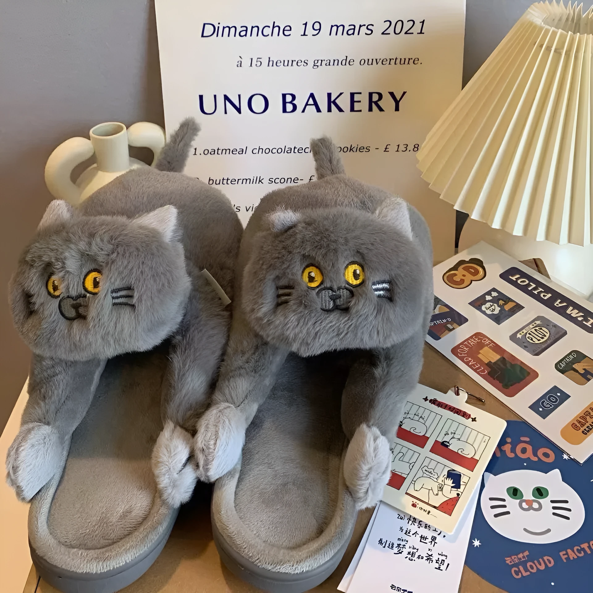 Pair of beige cat hug plush cotton slippers with non-slip sole on a soft floor