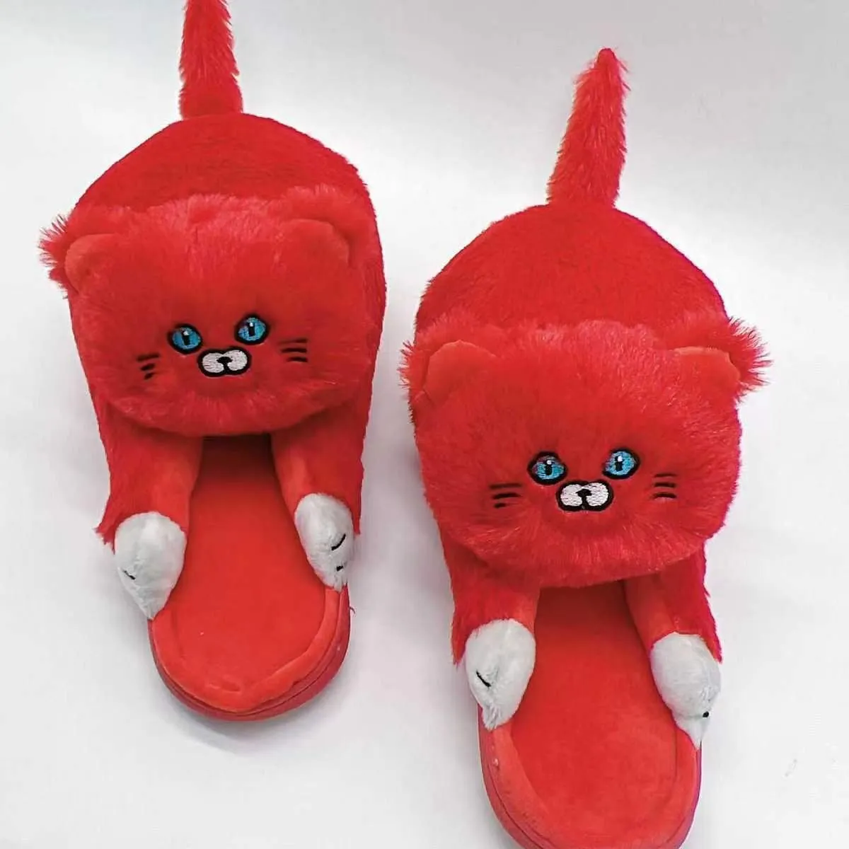 Pair of beige cat hug plush cotton slippers with non-slip sole on a soft floor