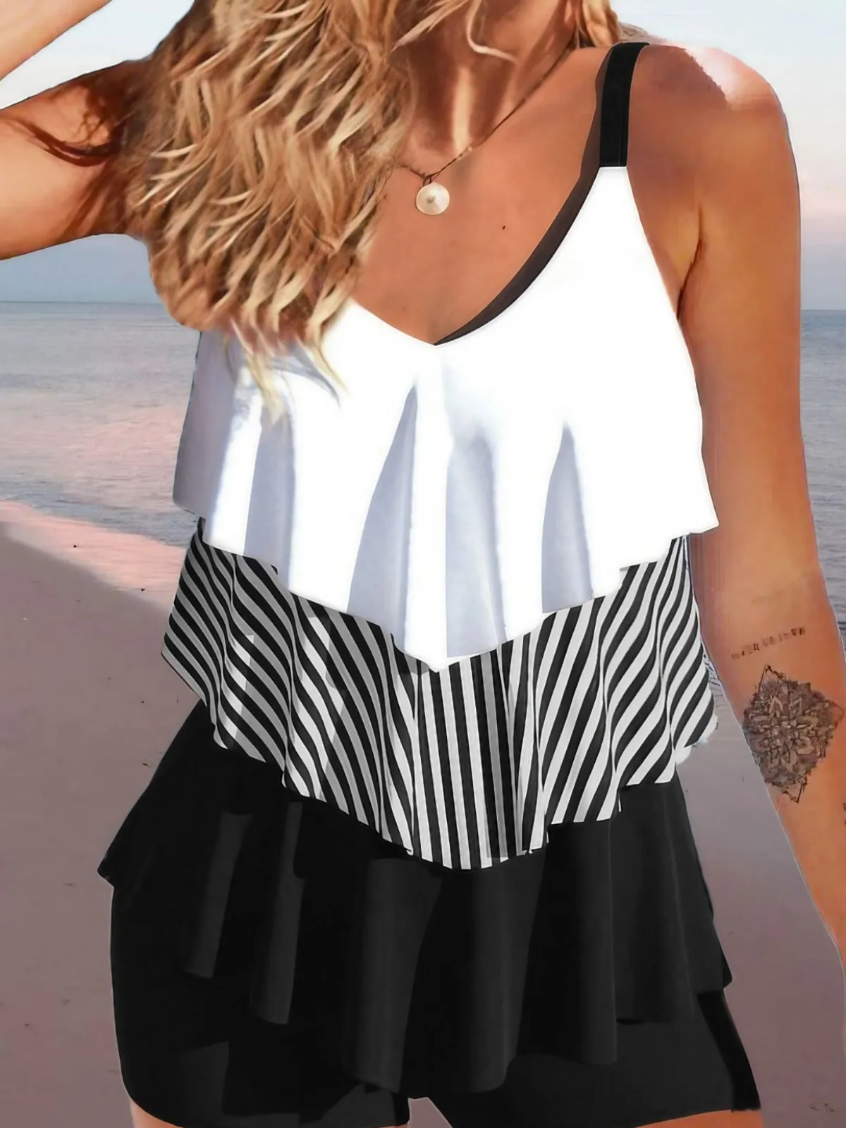 Women's sleeveless backless spaghetti-strap ruffle bikini swimsuit on a mannequin.