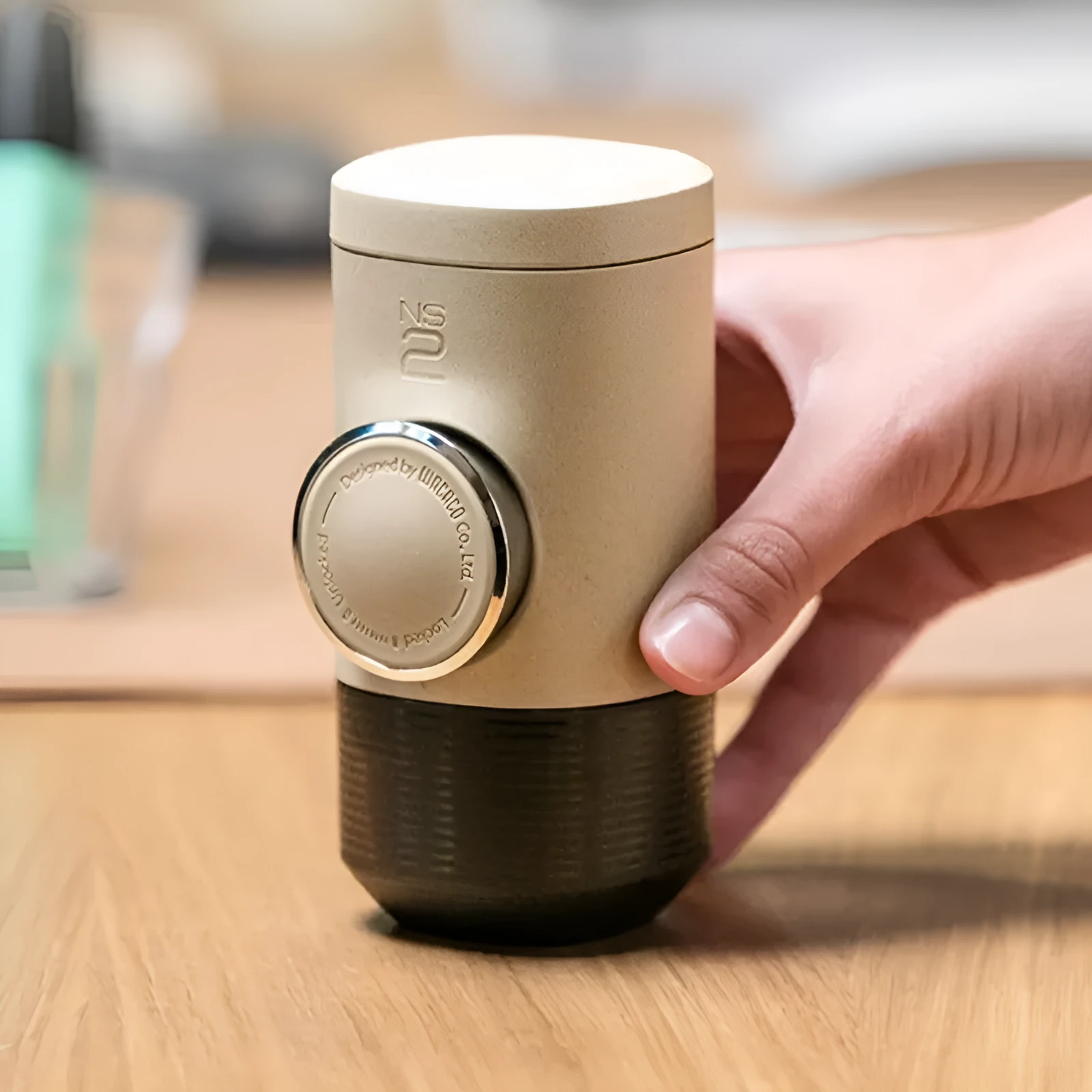 Manual espresso portable capsule coffee machine in olive gray with resin body, 129x70x60mm, on outdoor background