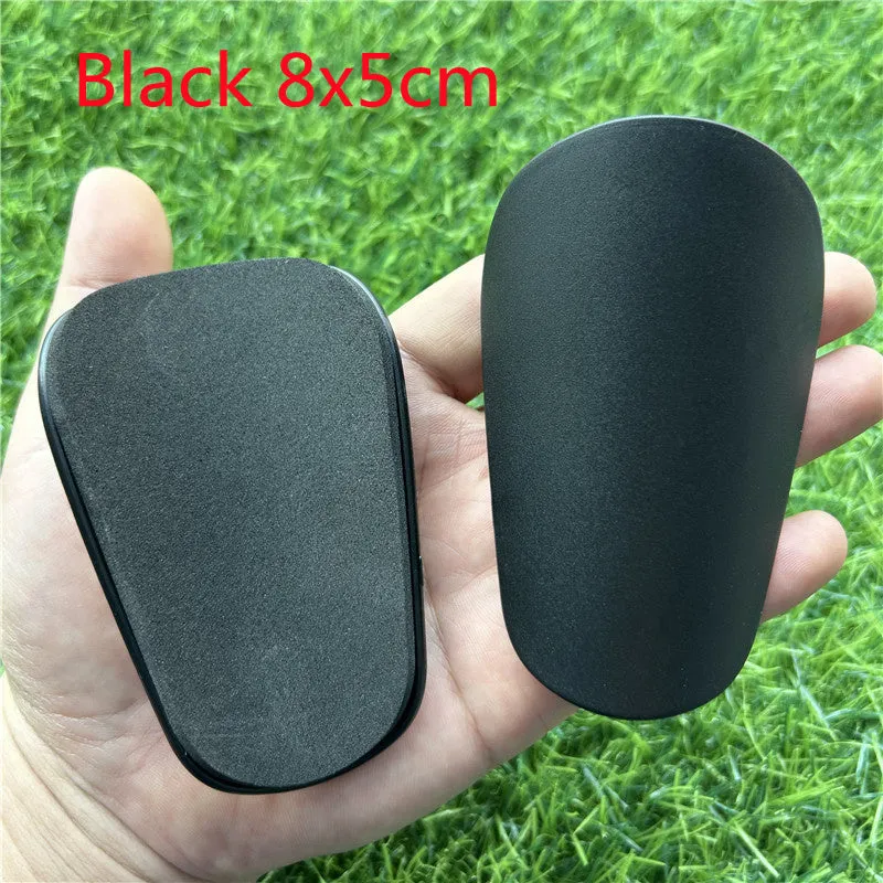Pair of small black plastic football shin guards for junior players