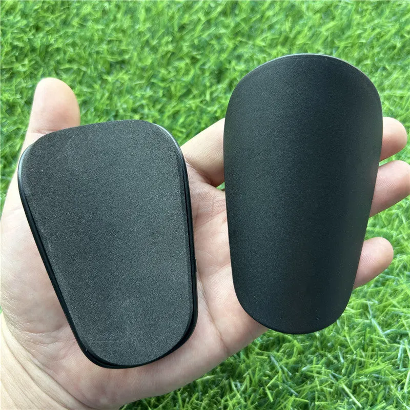 Pair of small black plastic football shin guards for junior players