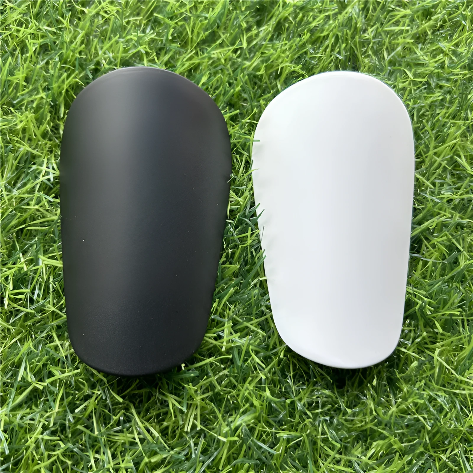 Pair of small black plastic football shin guards for junior players
