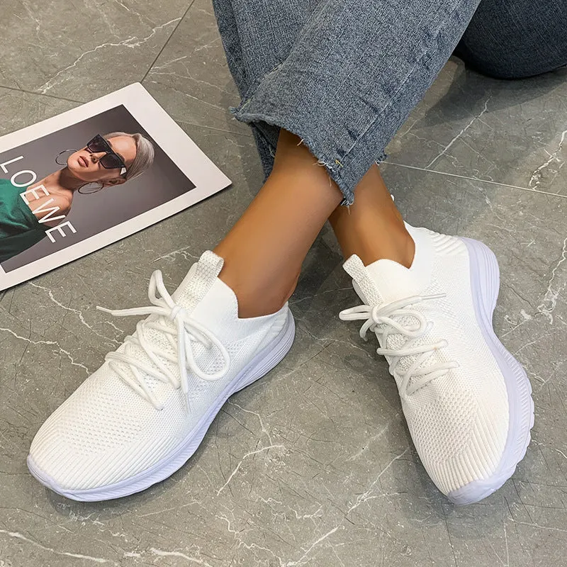 Women's low-top mesh running shoes in creamy white with a Flyknit upper and flat rubber sole.