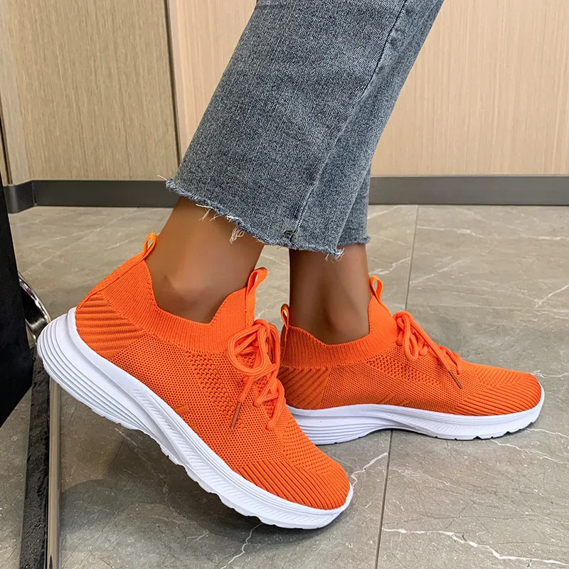 Women's low-top mesh running shoes in creamy white with a Flyknit upper and flat rubber sole.
