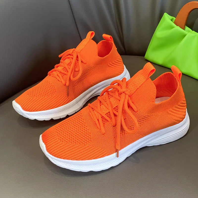 Women's low-top mesh running shoes in creamy white with a Flyknit upper and flat rubber sole.
