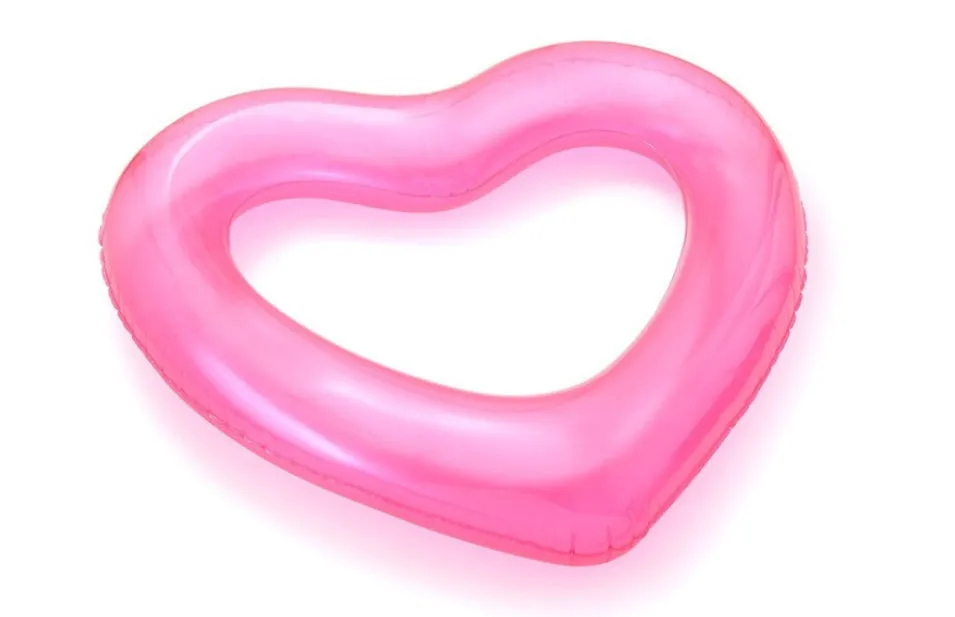 Oversized 120cm heart shaped swim ring in pink floating on water, adult outdoor pool toy