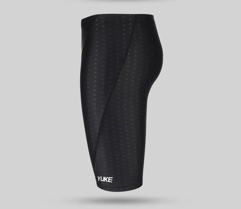 Men's black swimming set with briefs, goggles, cap, ear plugs, nose clip, and a carry bag laid out.