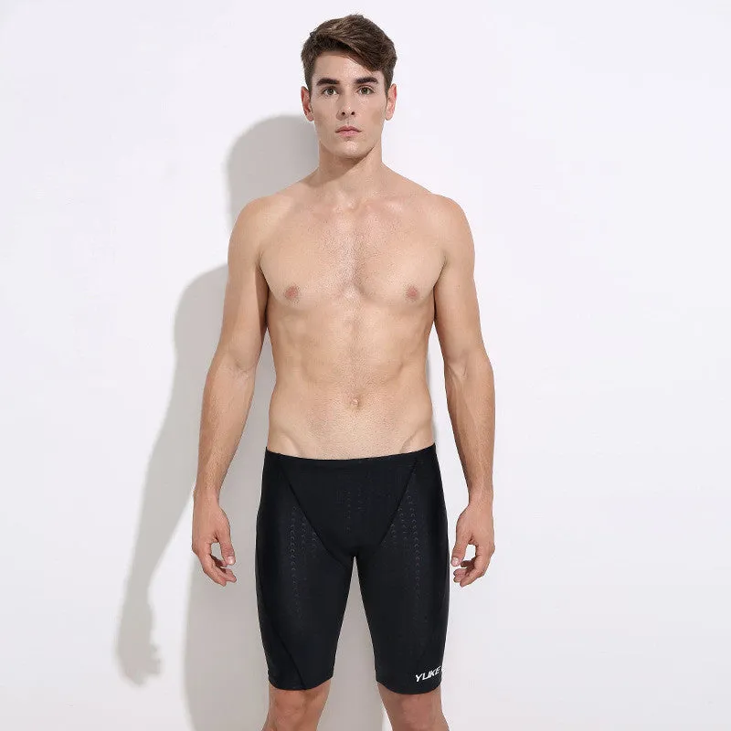 Men's black swimming set with briefs, goggles, cap, ear plugs, nose clip, and a carry bag laid out.