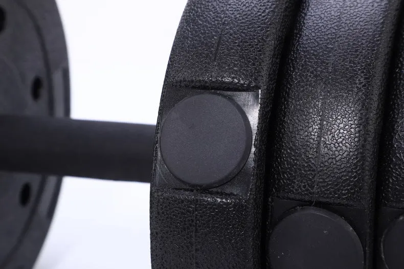 Pair of black rubber coated round head dumbbells 10kg each on a gym floor with indoor fitness equipment