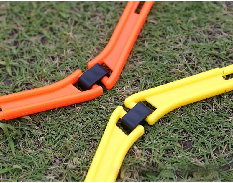 Set of six foldable yellow, green, and orange hexagon agility training rings on grass.
