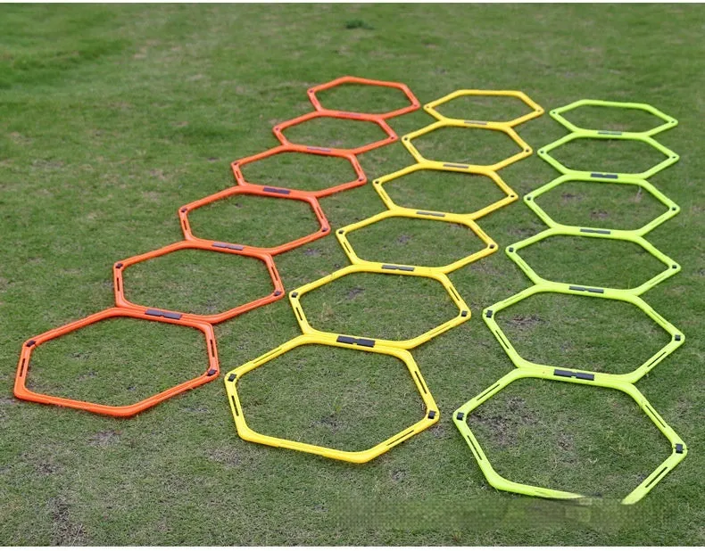 Set of six foldable yellow, green, and orange hexagon agility training rings on grass.