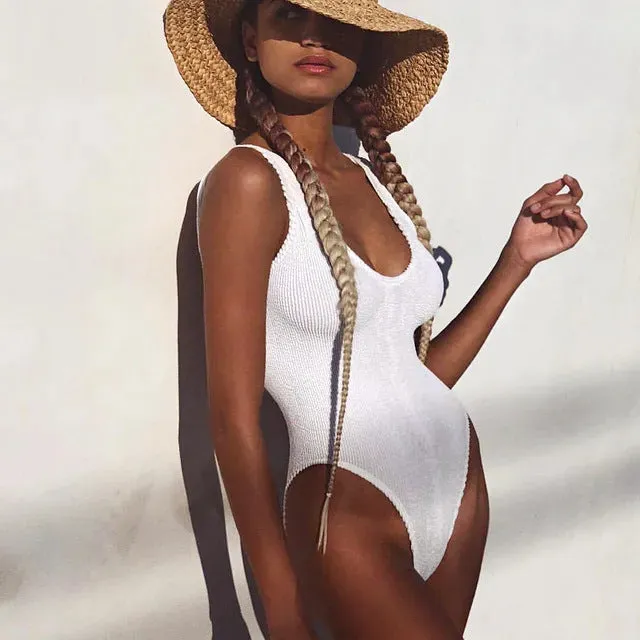 Solid colour seersucker fabric one-piece swimsuit with a backless design on an adult female mannequin.