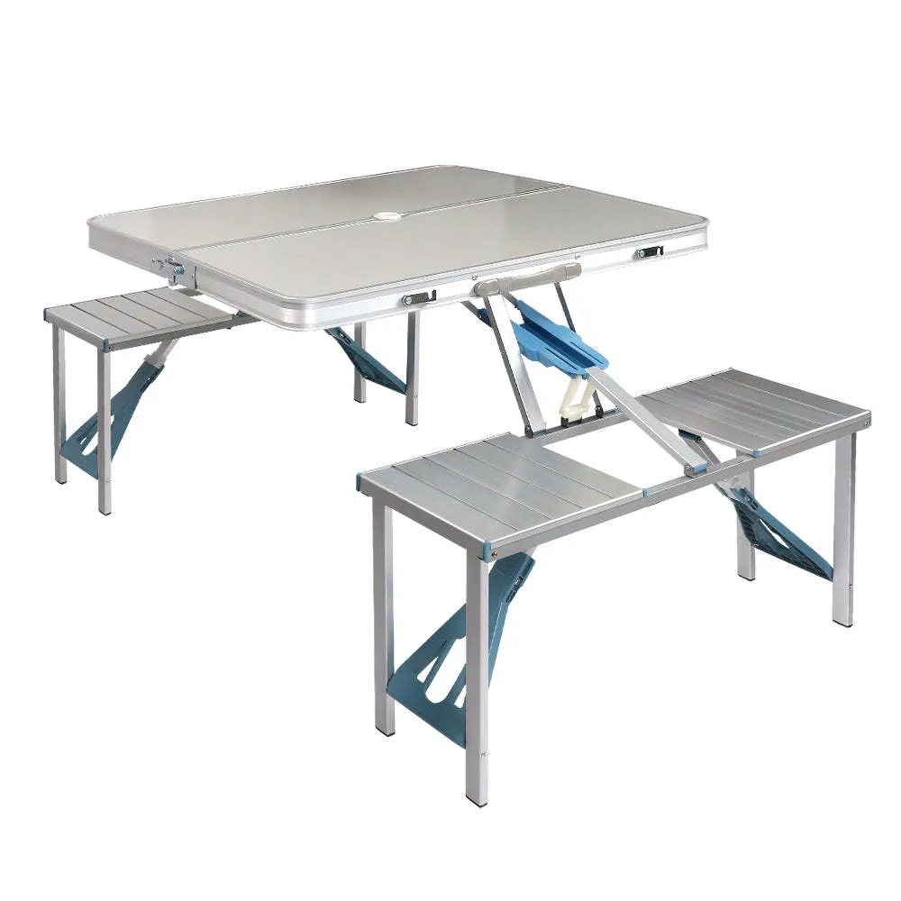 Outdoor folding table and chair set in aluminium alloy with four chairs, expanded on grass, silver gray colour, showing 85.5cm desktop and umbrella hole