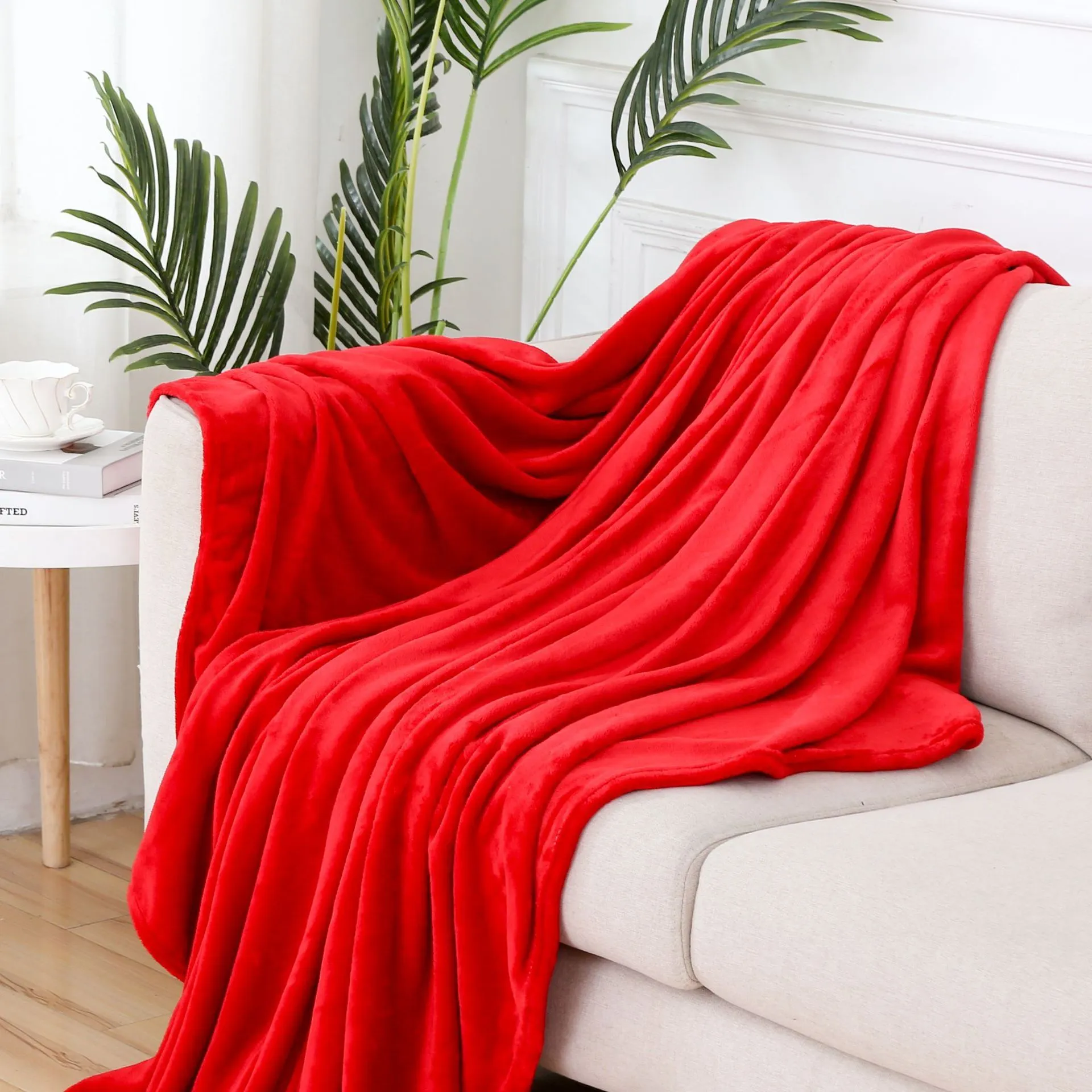 Solid colour polyester flannel blanket in big red, lying flat on a surface