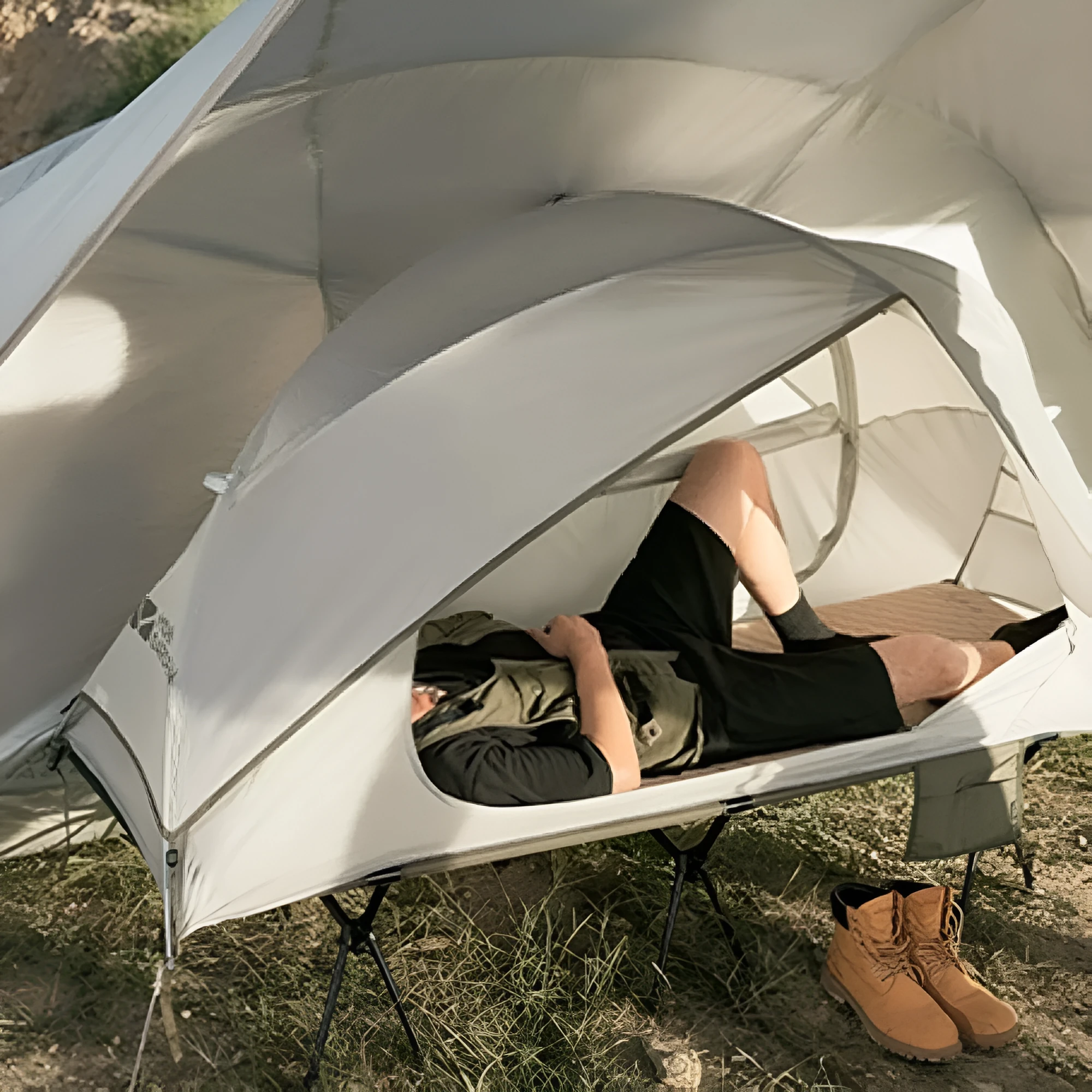 Ultra-light folding white single tent with aluminium poles on grass, 2.4kg
