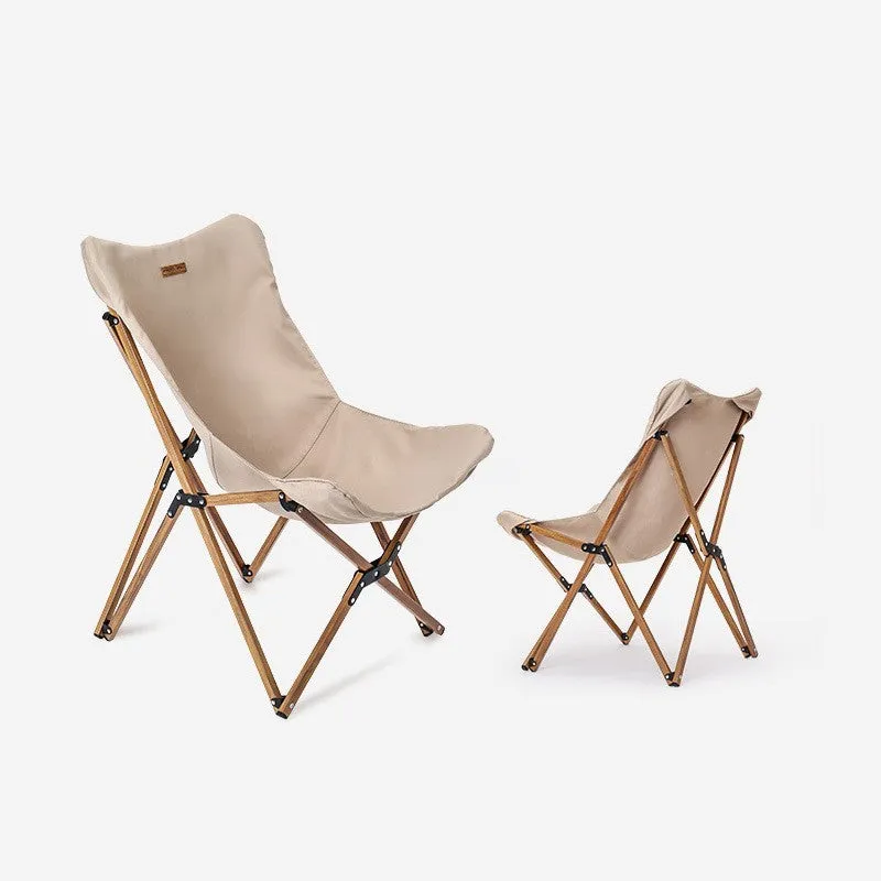 Folding camping chair with aluminium frame, wood grain finish, handrails, and rotating seat in outdoor setting