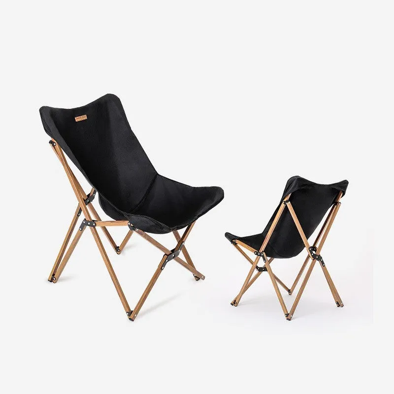 Folding camping chair with aluminium frame, wood grain finish, handrails, and rotating seat in outdoor setting
