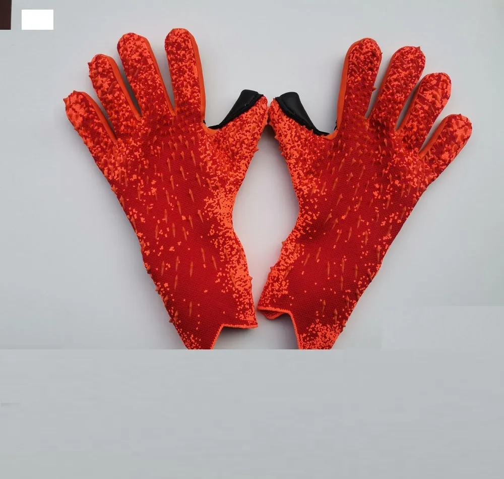 Childrens rubber goalkeeper training gloves in red, black, green and orange on green grass