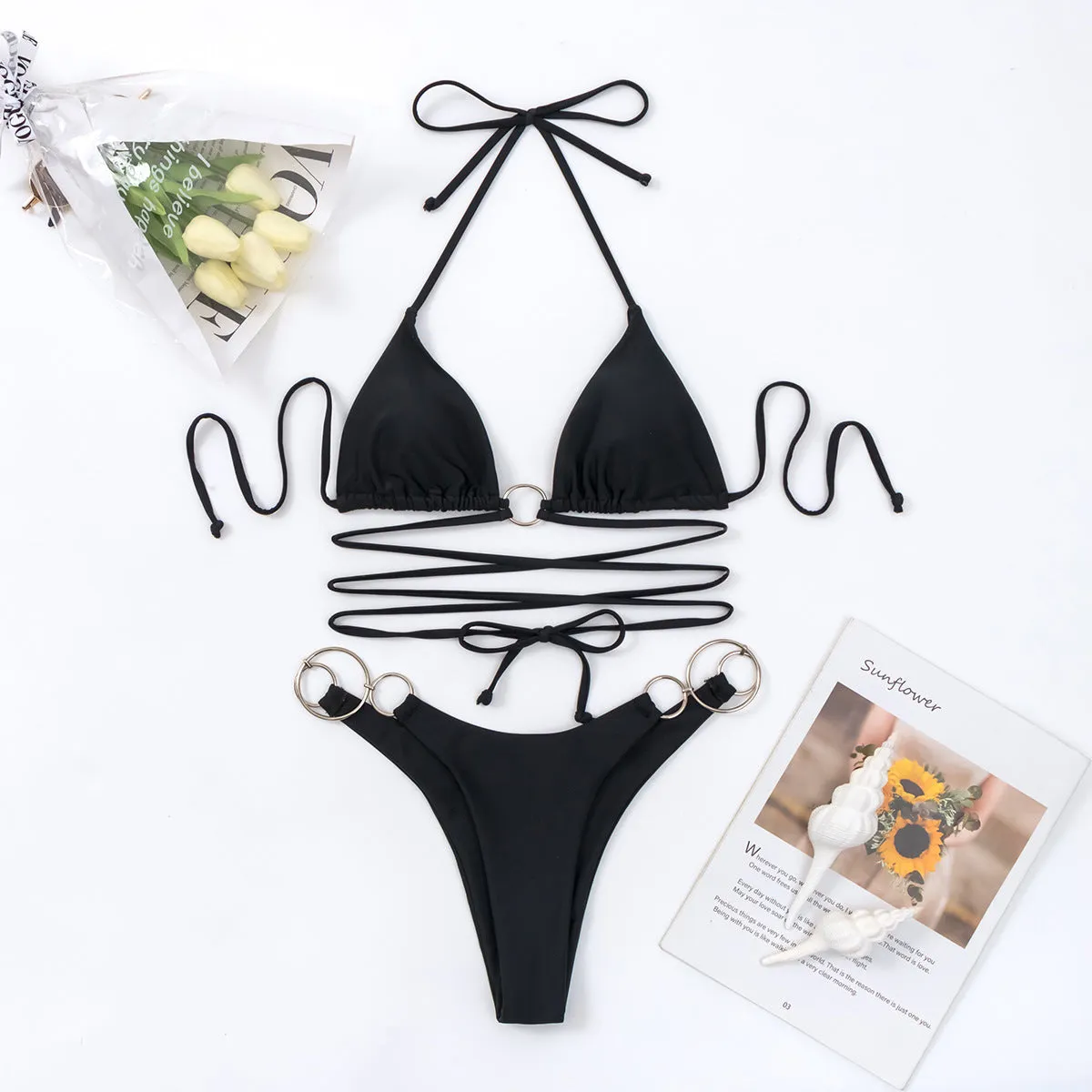 Black women's bikini set with metal ring straps and a backless, split cut design.
