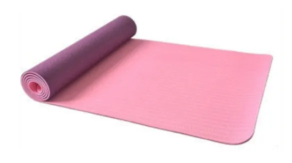 6mm TPE beginner yoga mat in black, rolled on wooden floor with textured non-slip surface visible