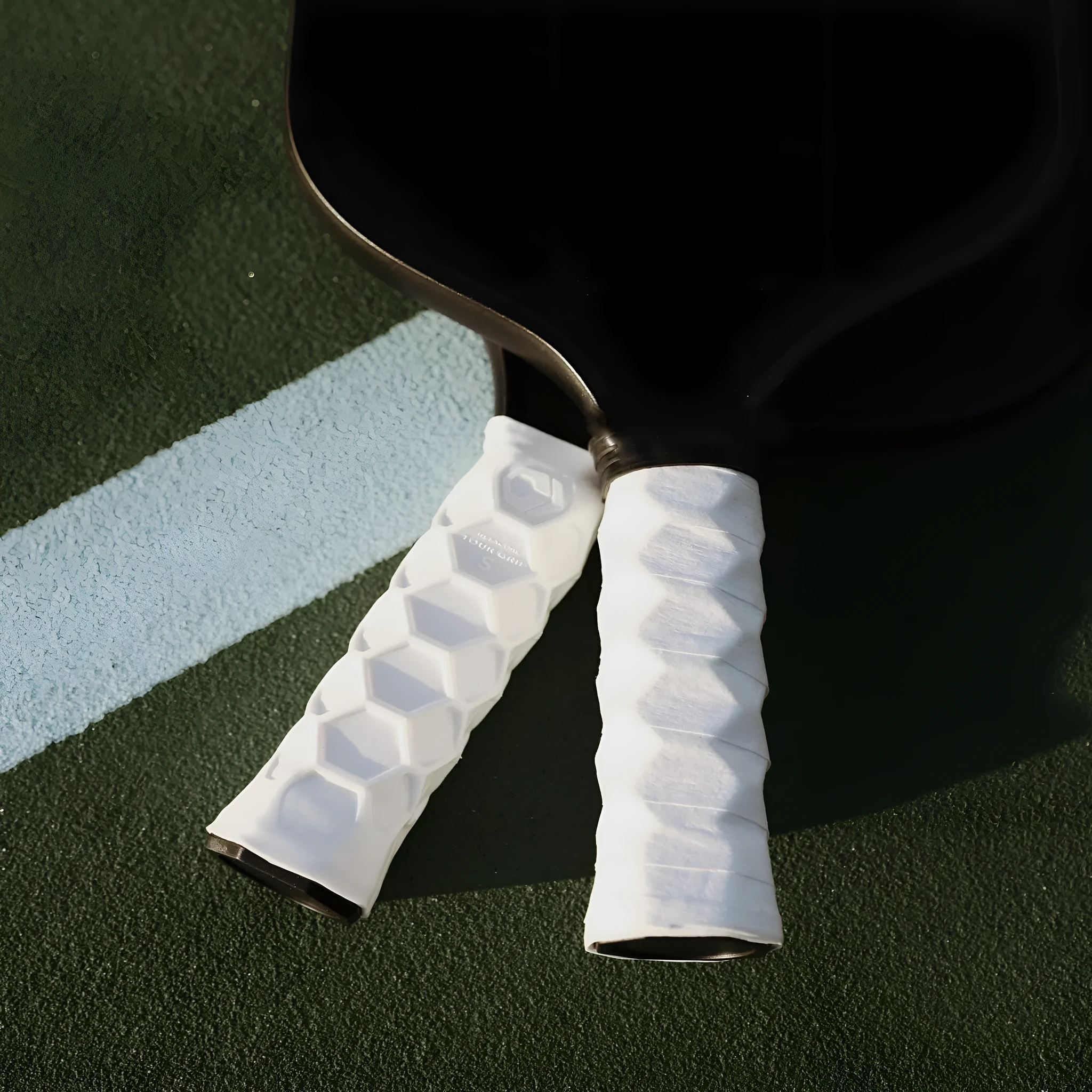 Silicone peak racket grip protective sleeve in black on a badminton racket handle