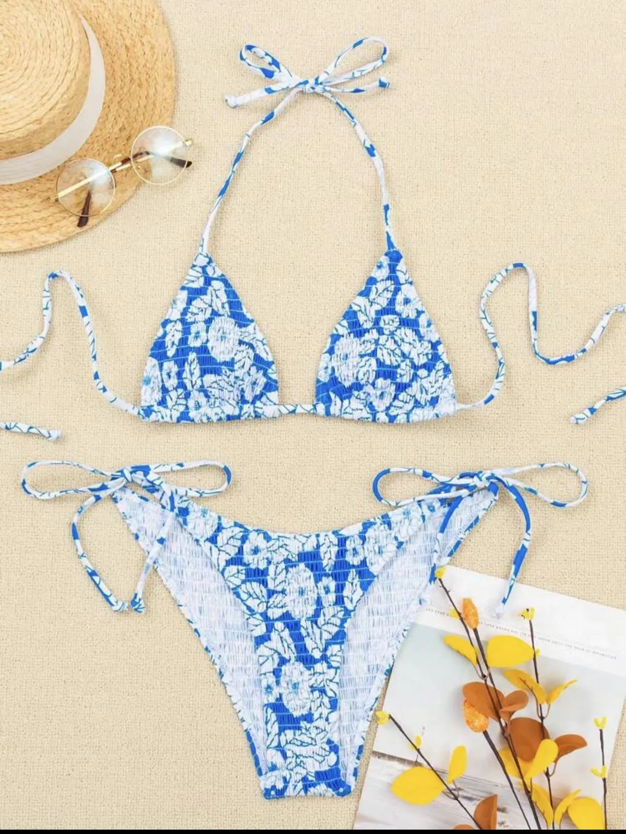 Women's floral print halter swimsuit briefs in light blue on a mannequin.
