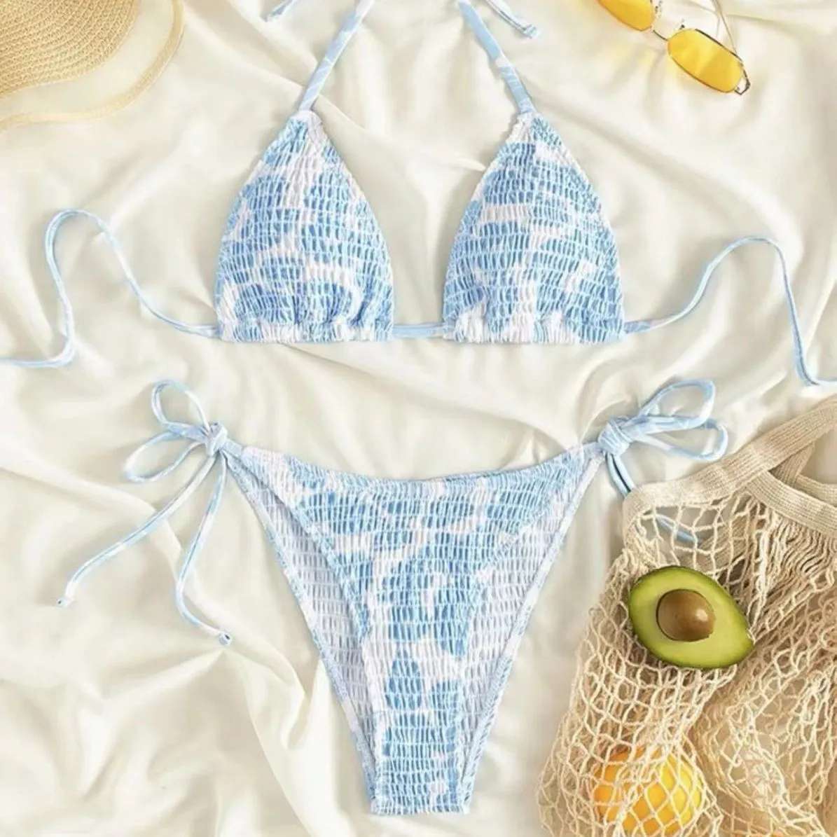 Women's floral print halter swimsuit briefs in light blue on a mannequin.