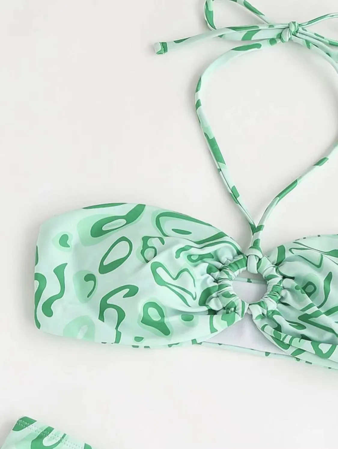 Women's blue floral bandeau bikini swimsuit with split style design on mannequin
