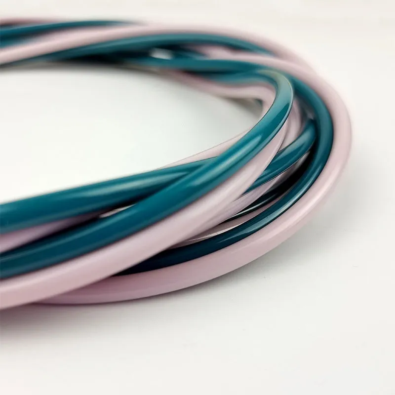 PVC bearing wire rope fitness skipping rope in peacock blue with handles on a plain background