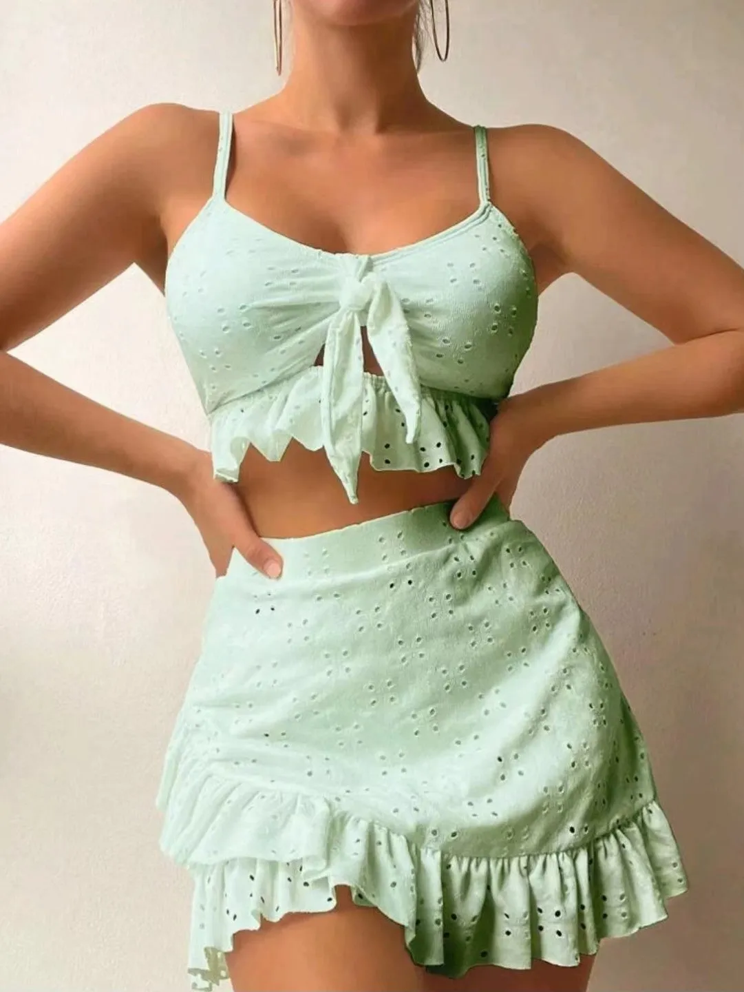 Women's solid colour split hip skirt bikini swimsuit three-piece set on a mannequin.
